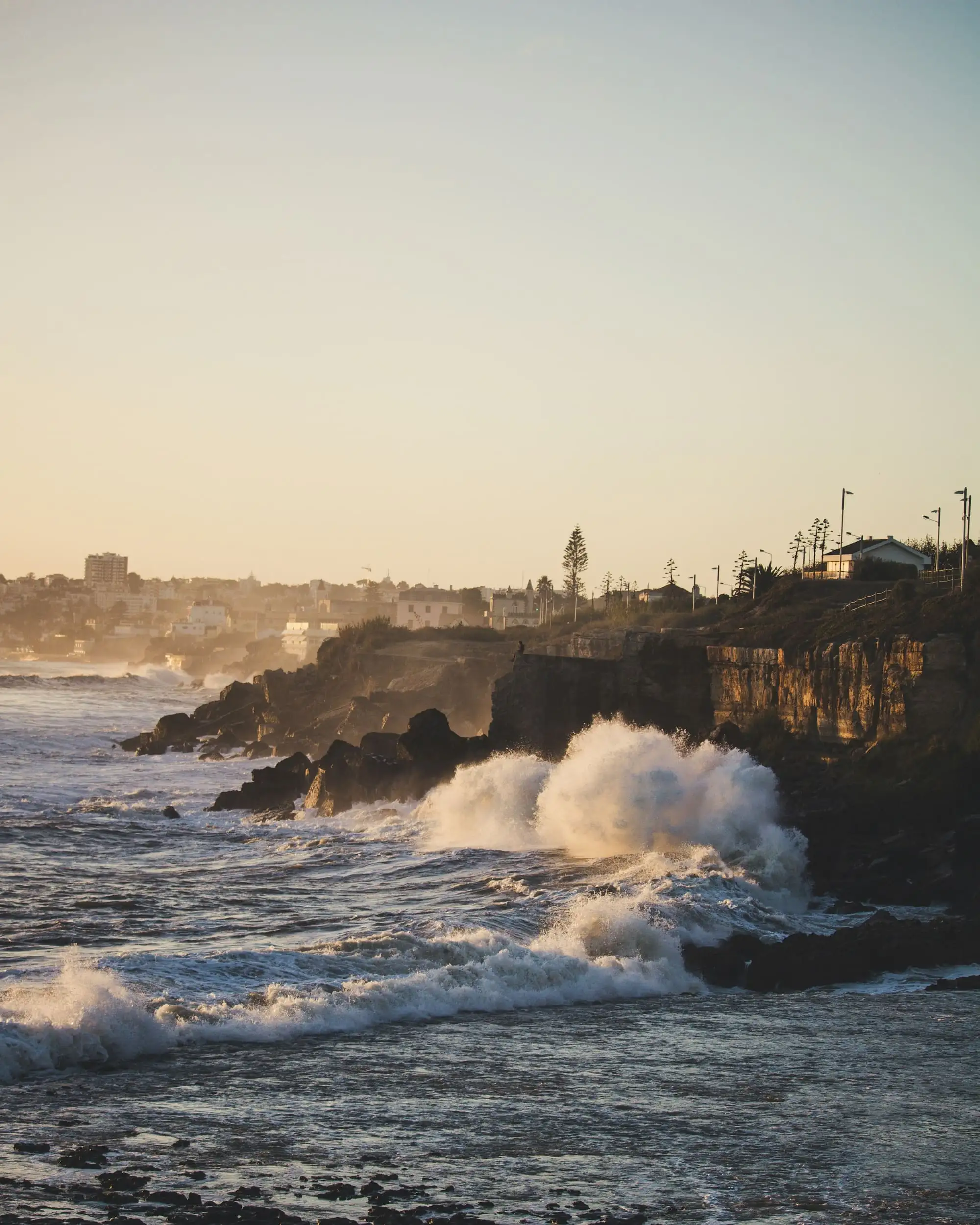 Waves breaking on the rocky coast near Estoril at sunset